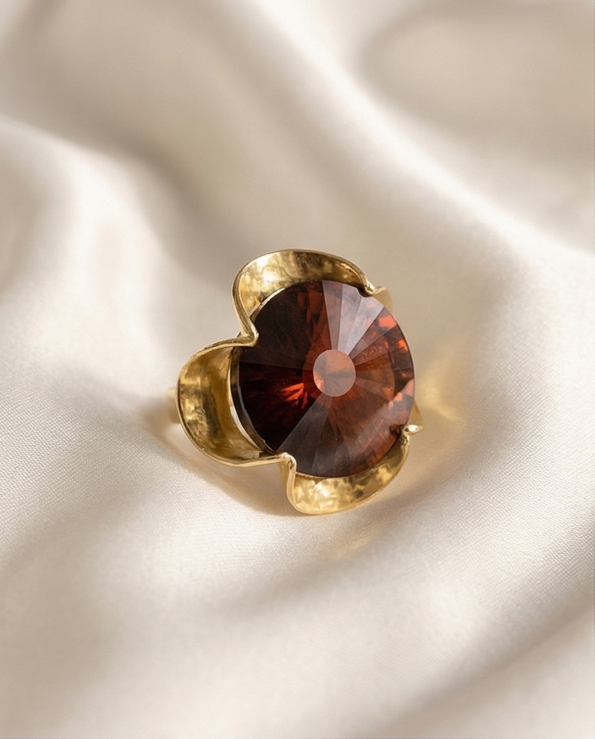 A silver ring combined with a crystal in the shade of garnet