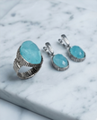 An oval silver ring with an ocean-hued opalite