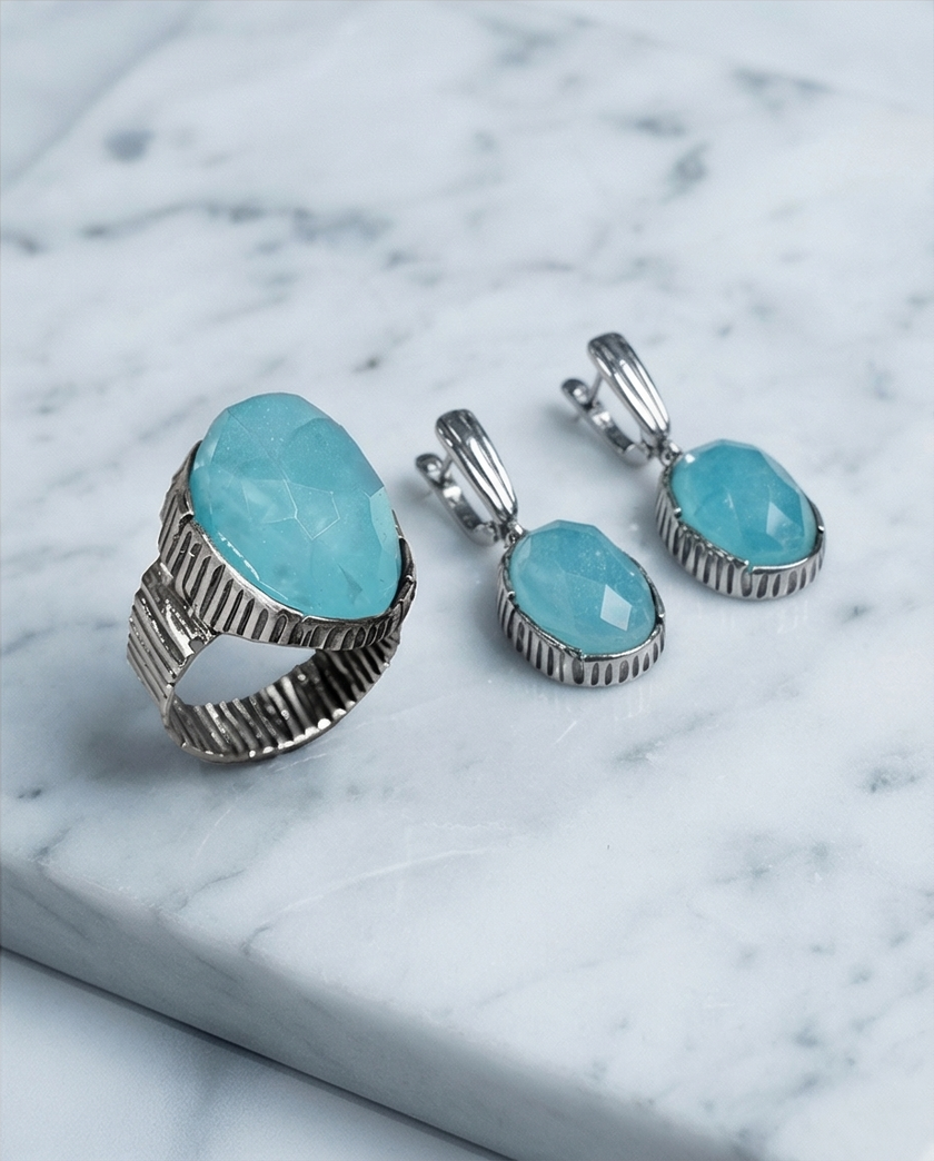 An oval silver ring with an ocean-hued opalite