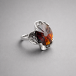 A silver ring combined with a crystal in the shade of garnet