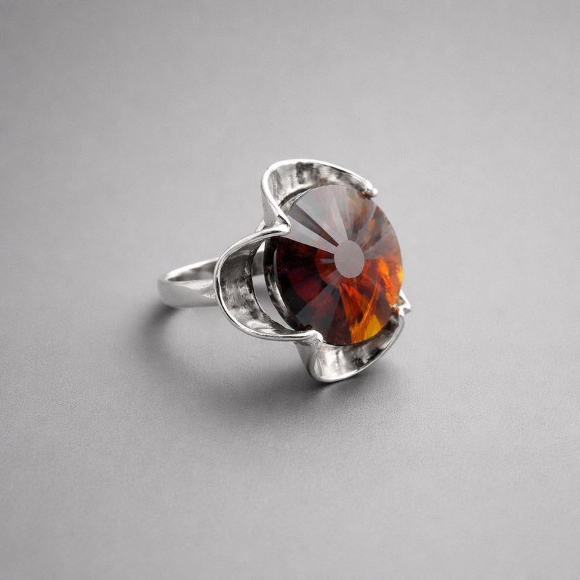 A silver ring combined with a crystal in the shade of garnet