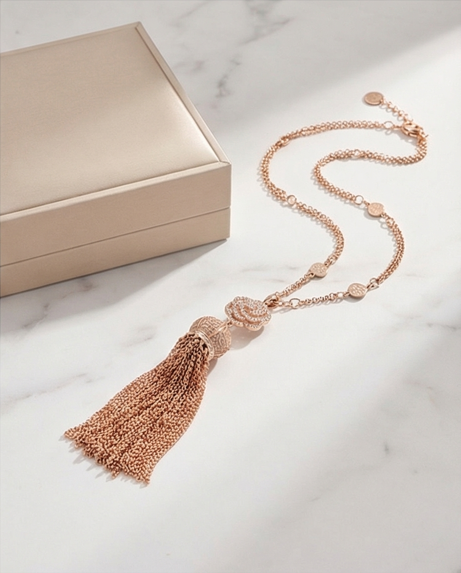 A rose gold tone necklace with a special pendant