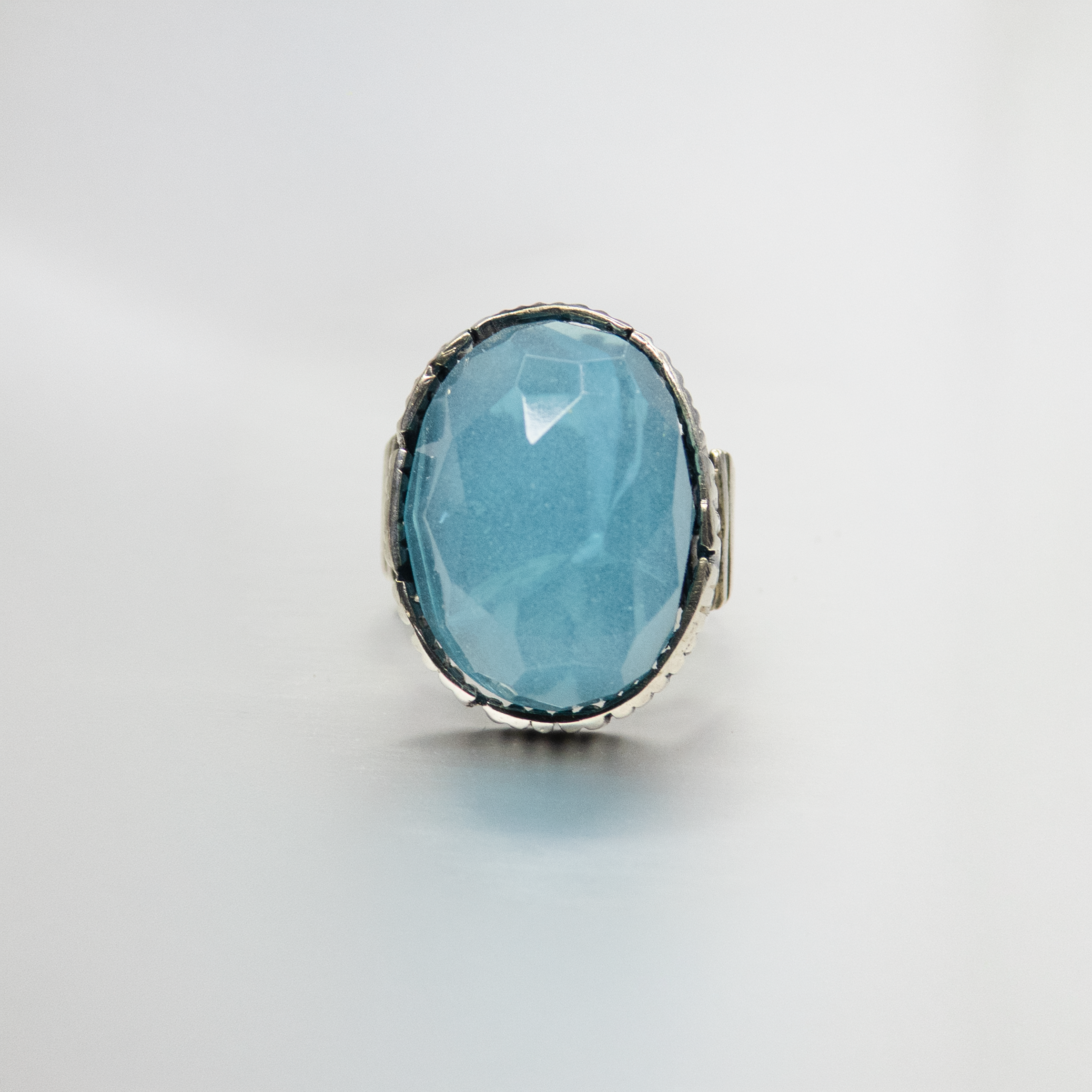 An oval silver ring with an ocean-hued opalite