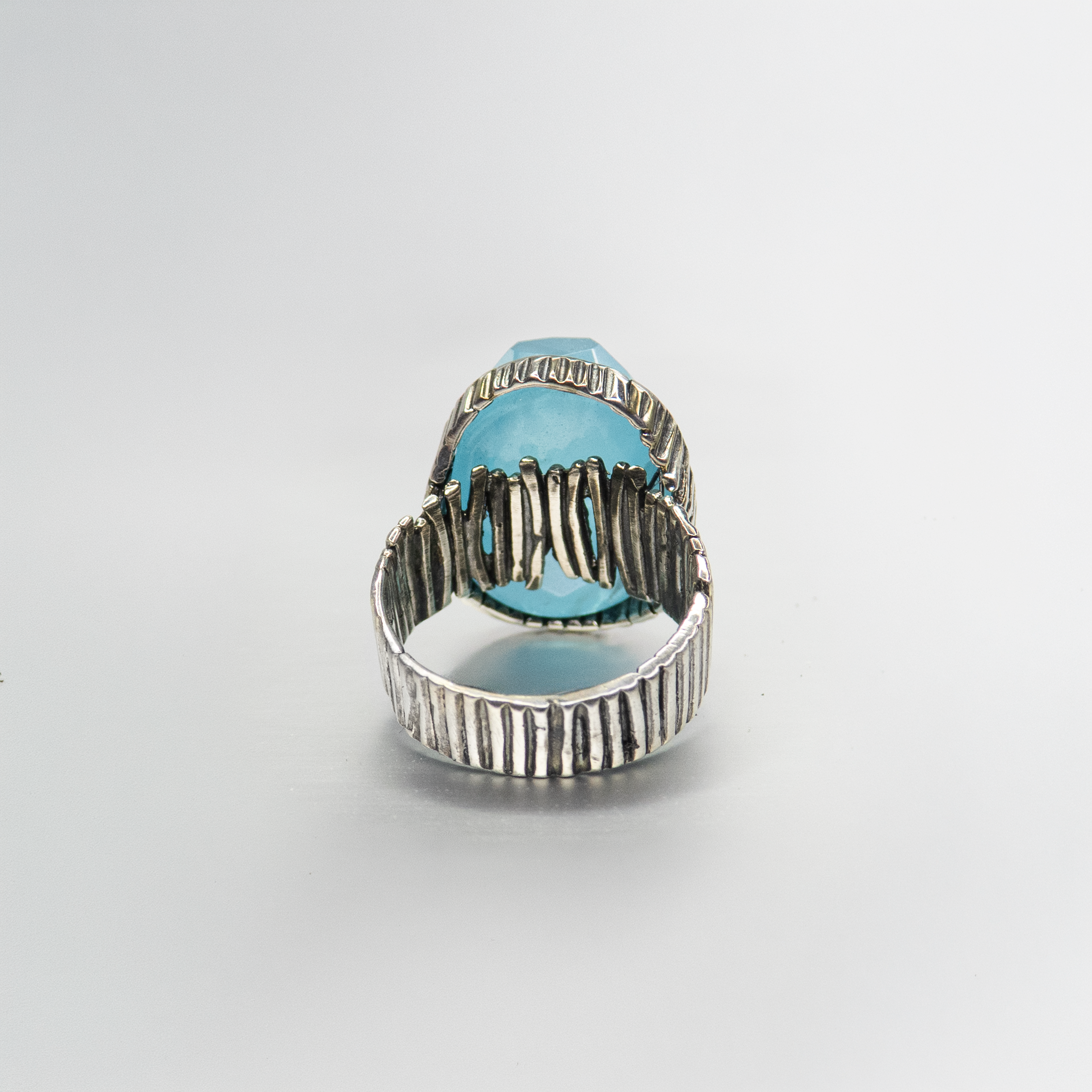 An oval silver ring with an ocean-hued opalite