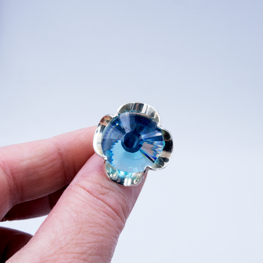 A silver ring combined with a crystal in a shade of aquamarine